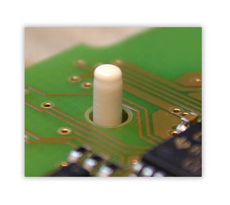 Die Leiterplatte wird in einem Kunststoff-Spritzgussteil mit vorbereiteten Domen positioniert.  Die durch die Leiterplatte geführten Kunststoff-Dome werden mit einem Stempel zu einer Niete umgeformt und die Leiterplatte somit in dem Kunststoffteil fixiert.